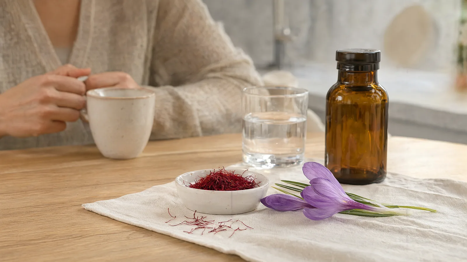 Saffron threads, crocus flowers and a capsule bottle on a kitchen table, illustrating saffron benefits for female health