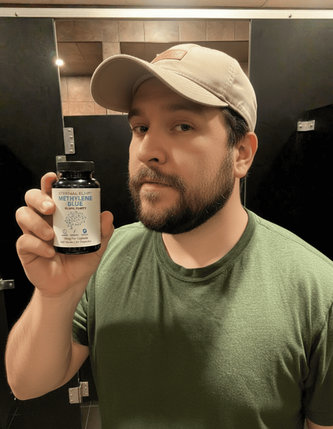 Person in a cap and green shirt holding an Eternal Elixir bottle